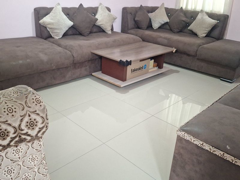 A living room area featuring large format light-colored porcelain floor tiles.