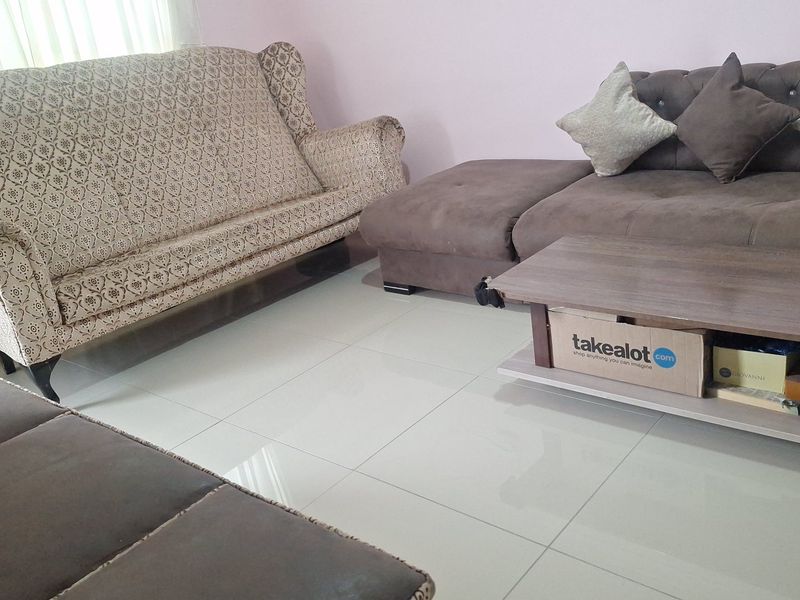 A living room area featuring neutral tiled flooring and a simple interior layout.
