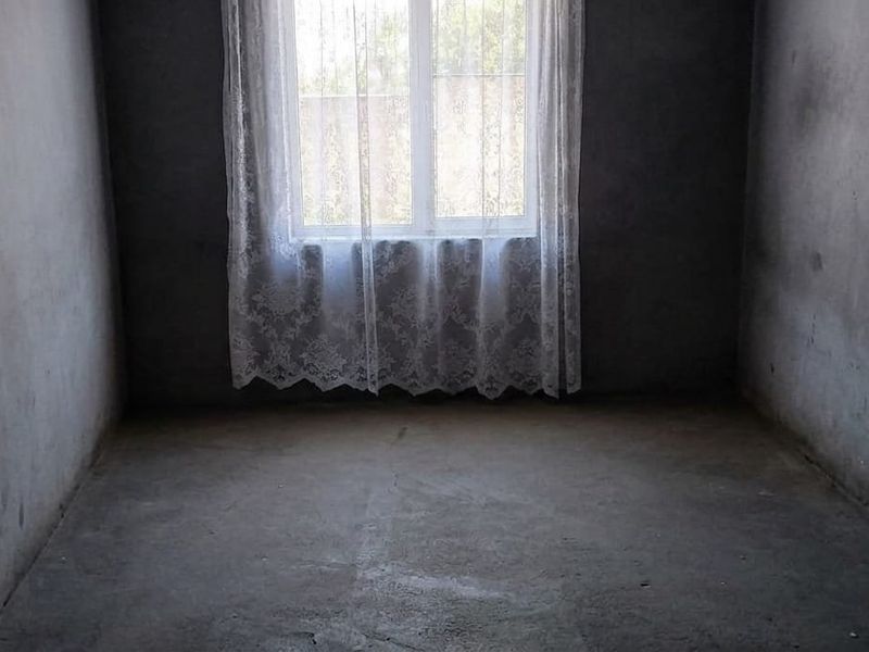 An unfinished bedroom space featuring bare concrete walls and flooring, ready for renovation and interior finishing.