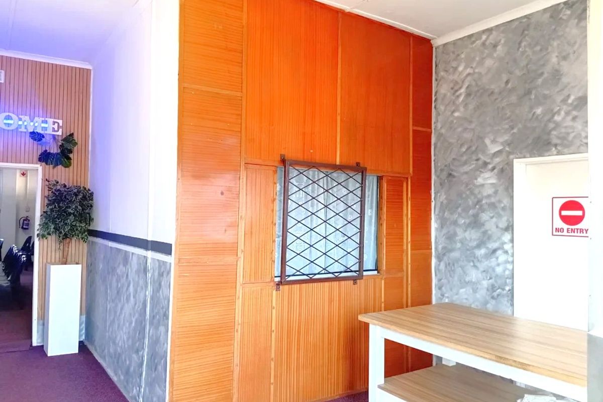 An entry area featuring wood paneling, textured wall finishes, and a built-in counter, providing a functional reception or transition space for the commercial property.