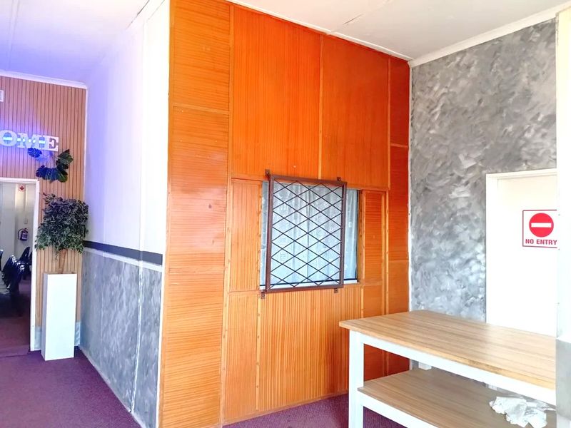 An entry area featuring wood paneling, textured wall finishes, and a built-in counter, providing a functional reception or transition space for the commercial property.