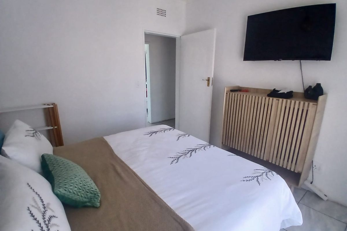 A functional bedroom featuring tiled flooring and a neutral interior finish, providing a clean and simple space.