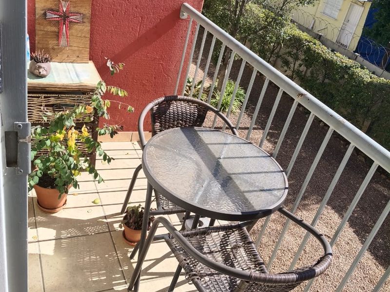 A compact balcony featuring tiled flooring and a metal balustrade, offering an outdoor space for relaxation.