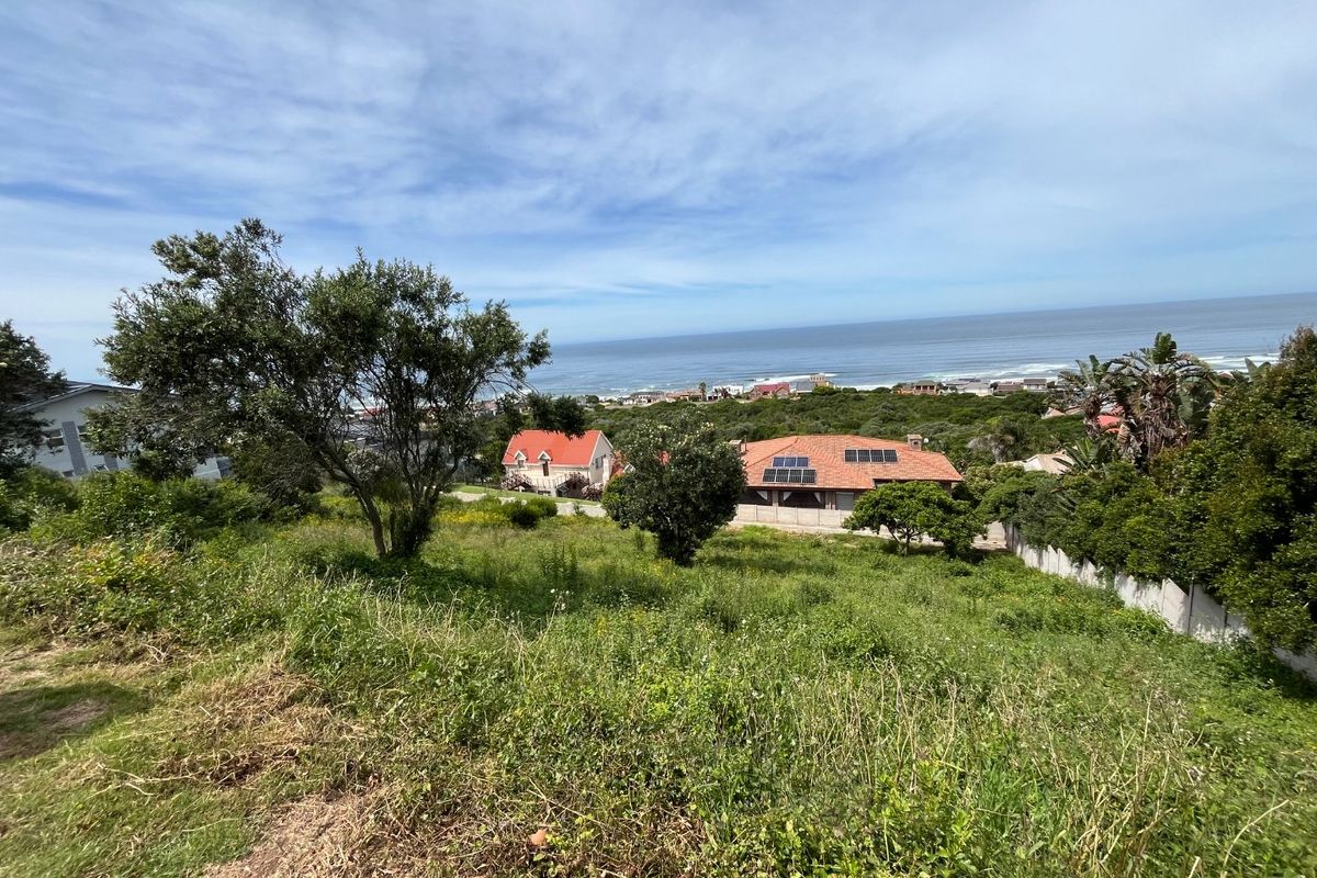 A view of the vacant residential land featuring a sloped grassy terrain with coastal views in the background.