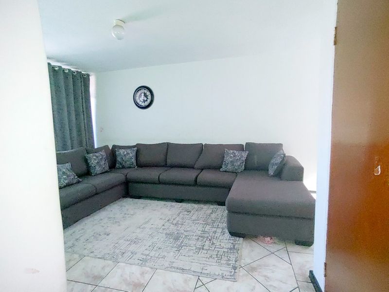A living room area featuring tiled flooring and neutral wall finishes.