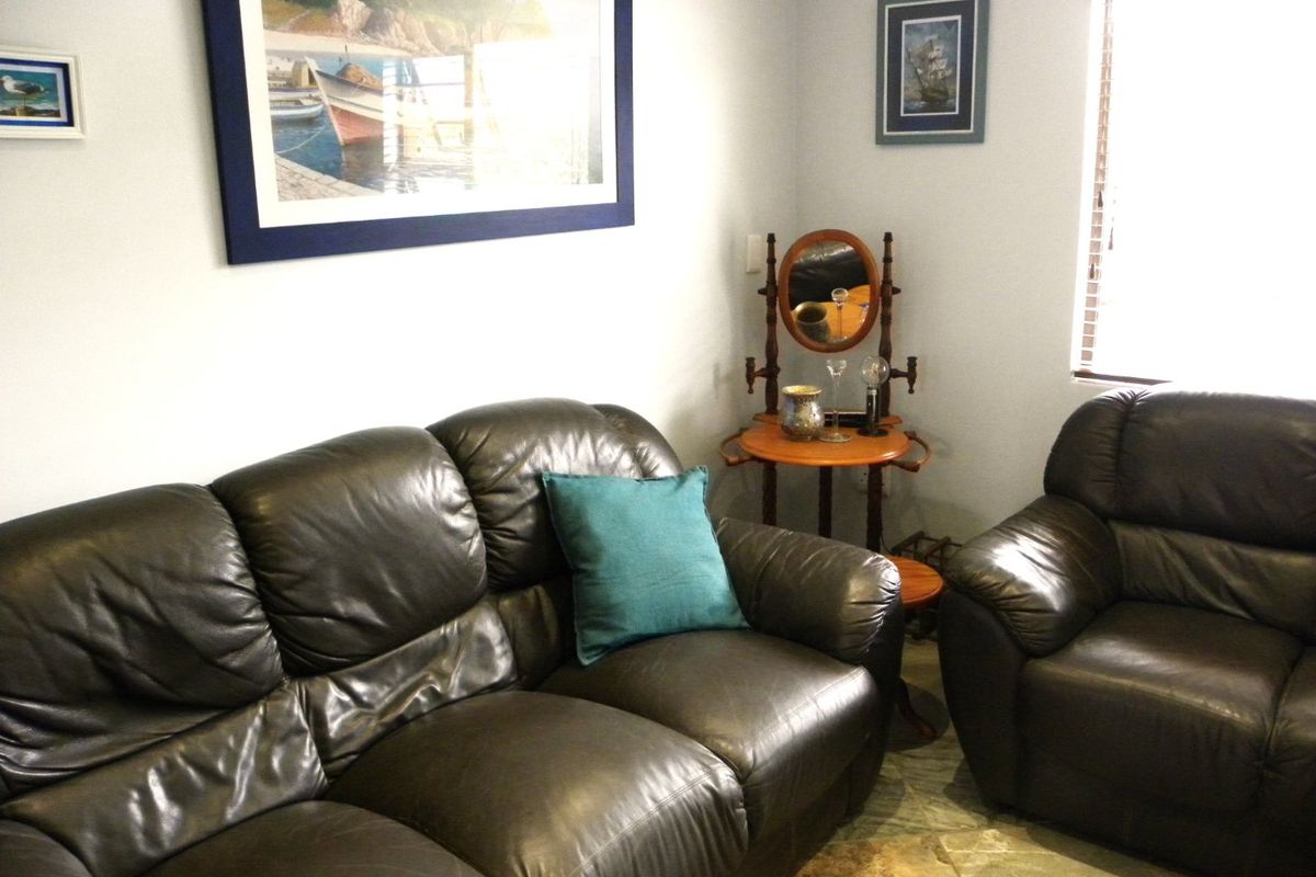 A comfortable living room area featuring tiled flooring and window blinds, providing a neutral base for interior design updates.