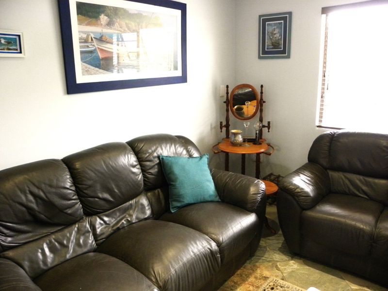 A comfortable living room area featuring tiled flooring and window blinds, providing a neutral base for interior design updates.