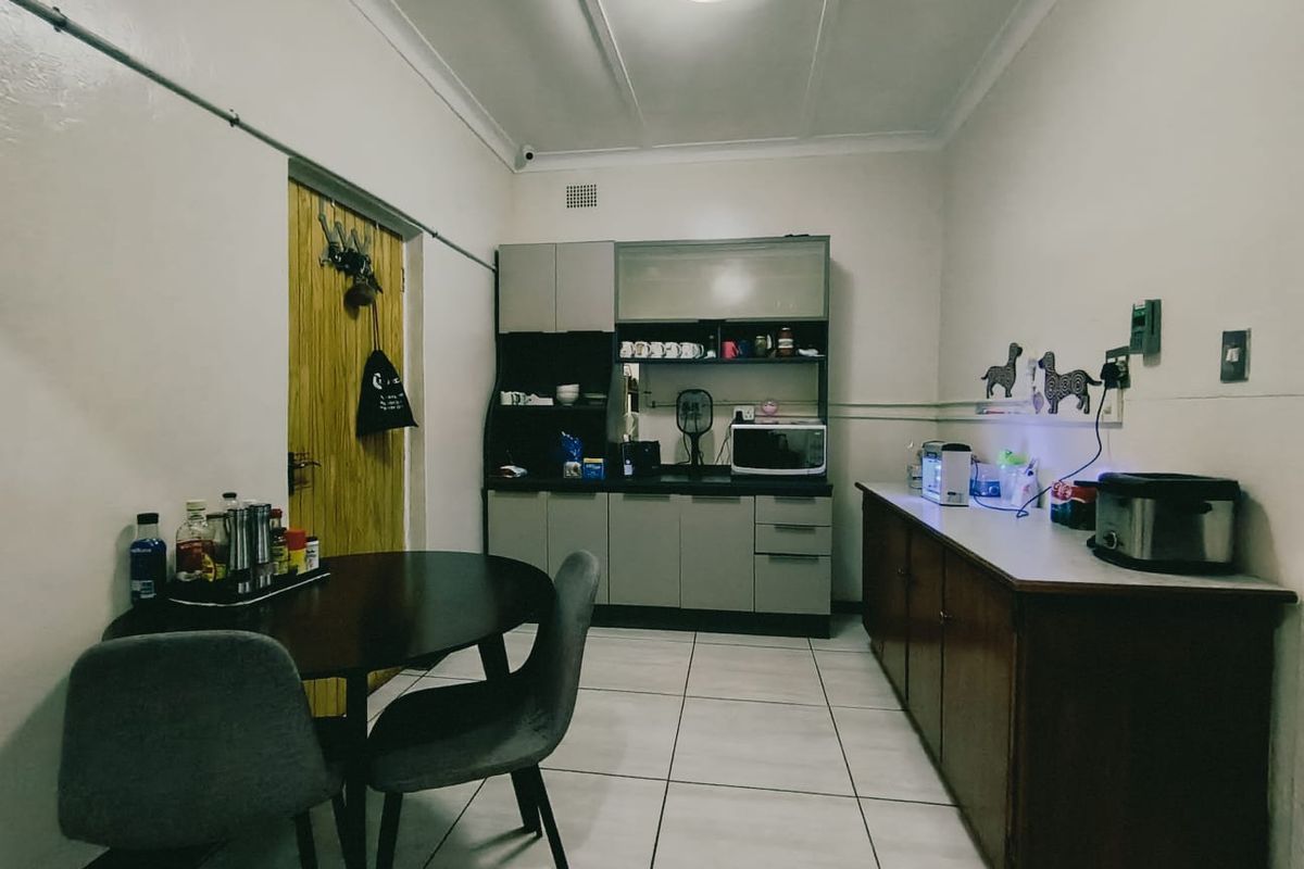 A functional kitchen area featuring built-in cabinetry, laminate countertops, and tiled flooring, providing a practical space for meal preparation and dining.