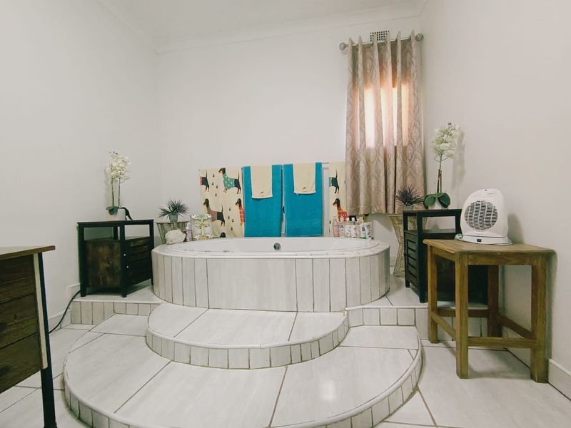 A bathroom featuring a raised, tiled built-in bathtub with steps, providing a central focal point in the room.