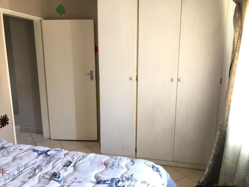 A bedroom featuring built-in cupboards and tiled flooring, providing functional storage and a neutral base for interior design.