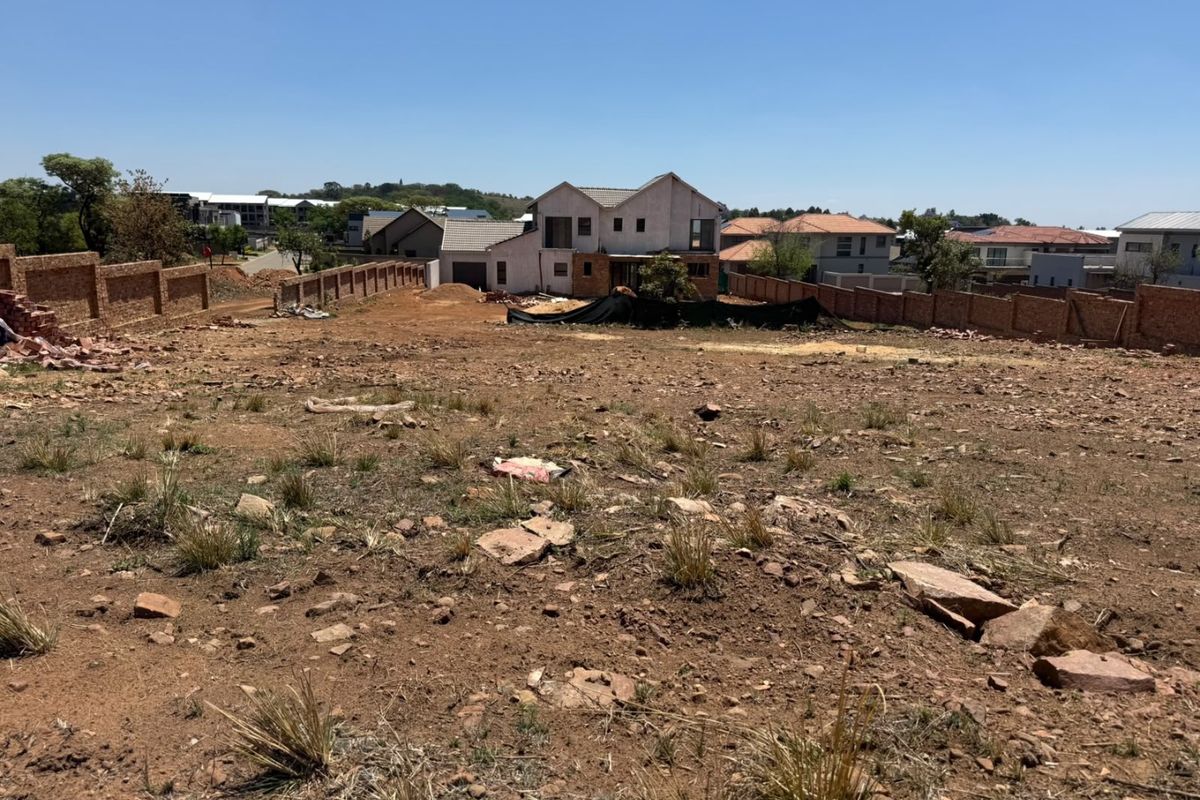 A large, undeveloped residential plot of land featuring perimeter brick walling, offering a blank canvas for future landscaping or construction projects.