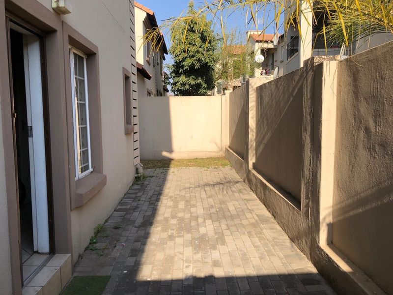 A paved rear courtyard area enclosed by high boundary walls, providing a private outdoor space accessible from the main dwelling.