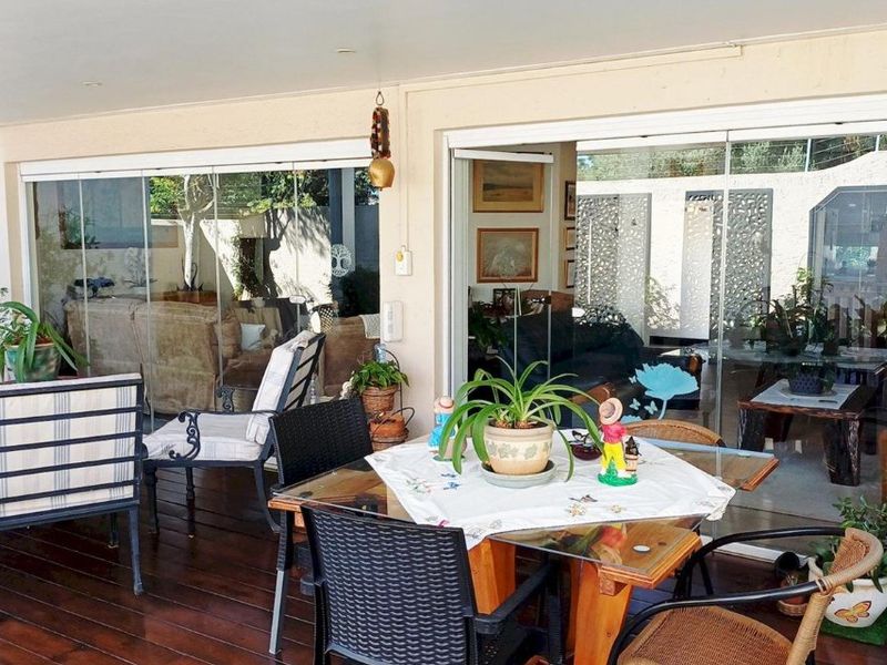 A covered patio area featuring timber decking and large sliding glass doors that provide seamless access to the interior living space.