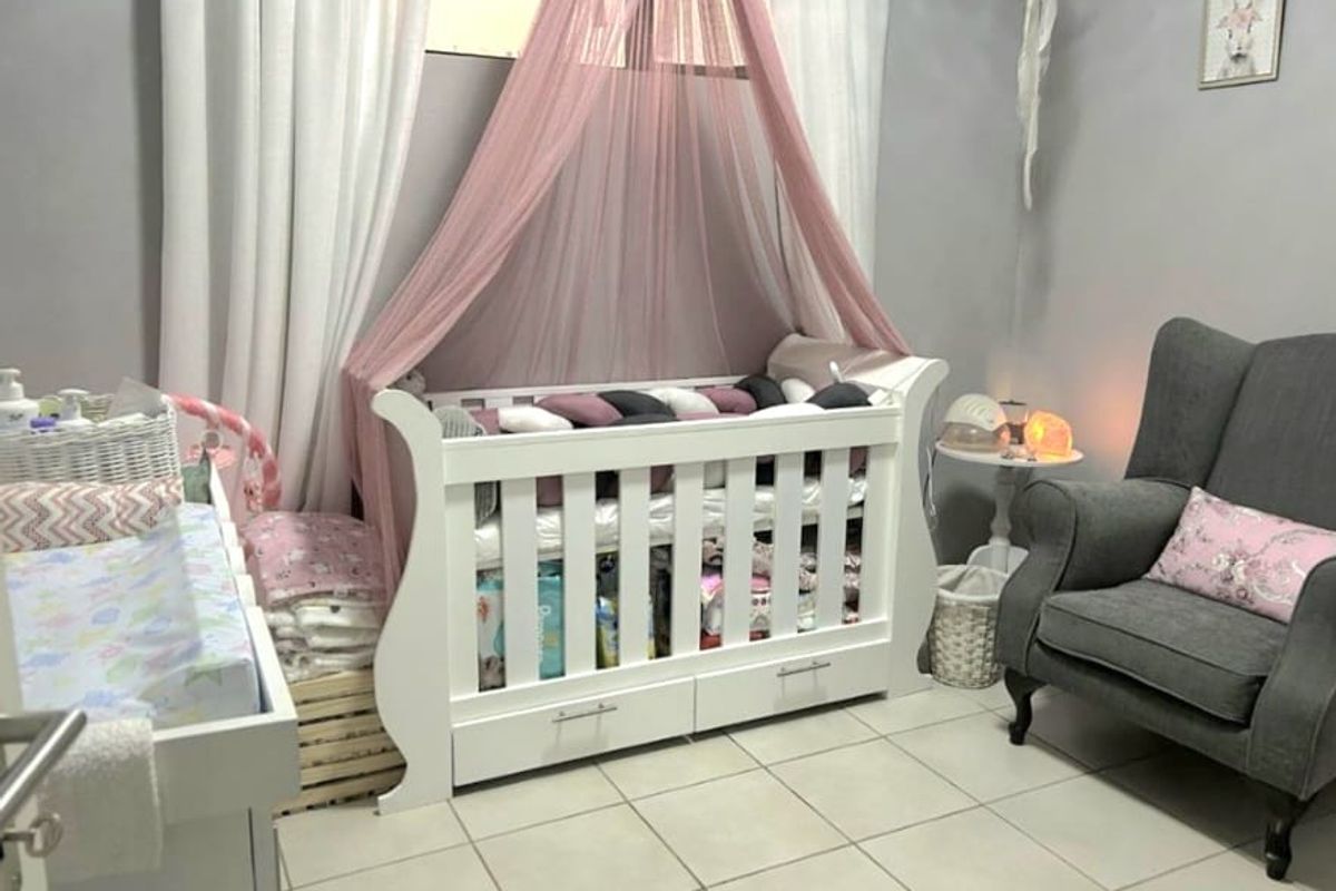 A nursery bedroom featuring neutral wall paint and light-colored floor tiles.