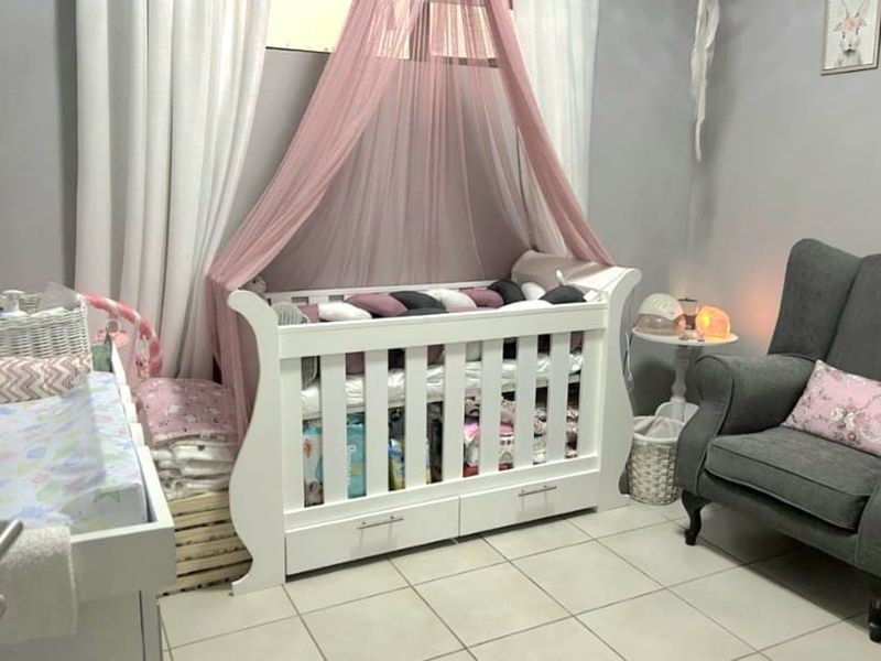 A nursery bedroom featuring neutral wall paint and light-colored floor tiles.