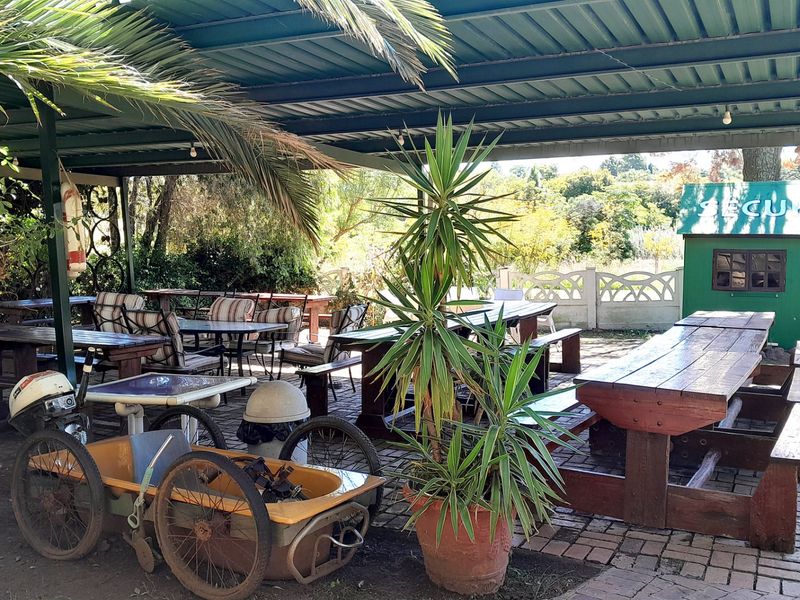 A covered outdoor patio area featuring brick paving and a metal roof structure, suitable for outdoor entertainment and dining.