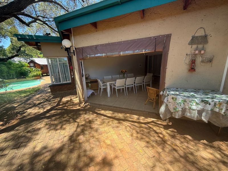 Covered outdoor patio area featuring tiled flooring and a retractable canvas awning, providing a functional space for outdoor dining and entertaining.