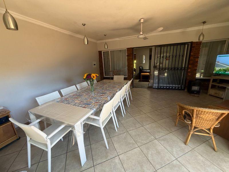 Spacious covered patio area featuring tiled flooring, ceiling fan, and direct access to the interior through a secure gate.