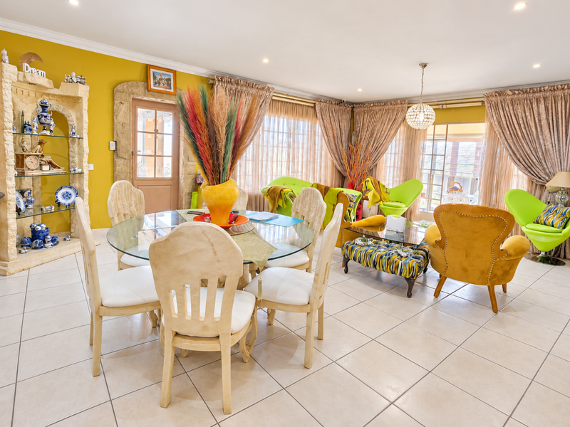 Spacious open-plan living and dining area featuring tiled flooring, recessed lighting, and a unique built-in stone display unit with decorative architrave.
