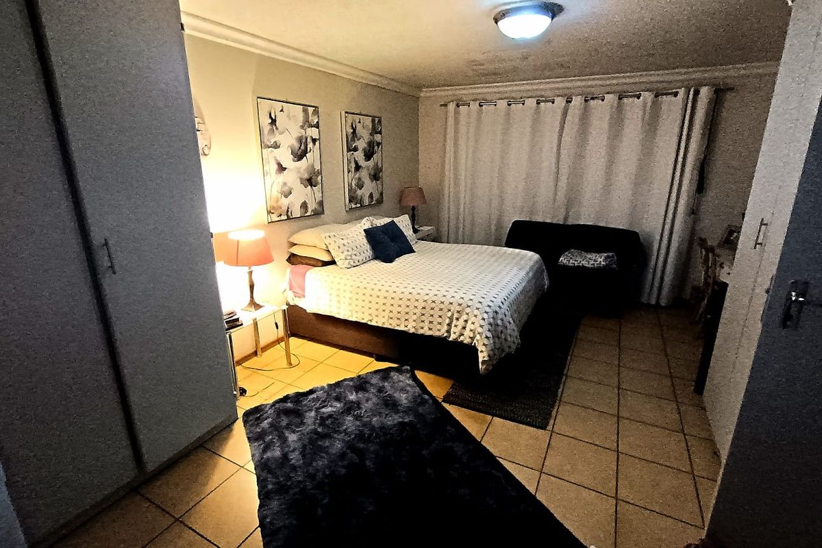 A bedroom featuring tiled flooring, a built-in wardrobe, and curtain rails, providing a functional space with standard finishes.