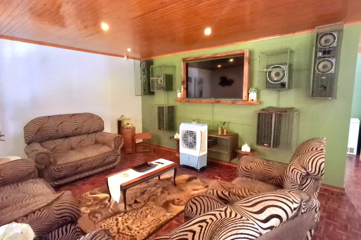 A living room featuring warm timber ceiling paneling and traditional parquet flooring, providing a classic foundation for interior updates.