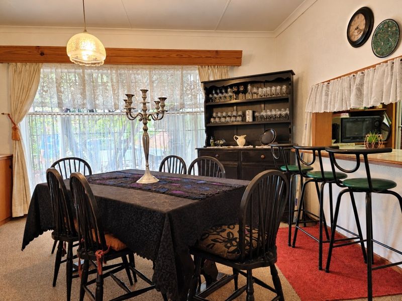 Dining area featuring a breakfast bar, timber window pelmet, and coved ceiling, providing a functional space for meals and entertaining.