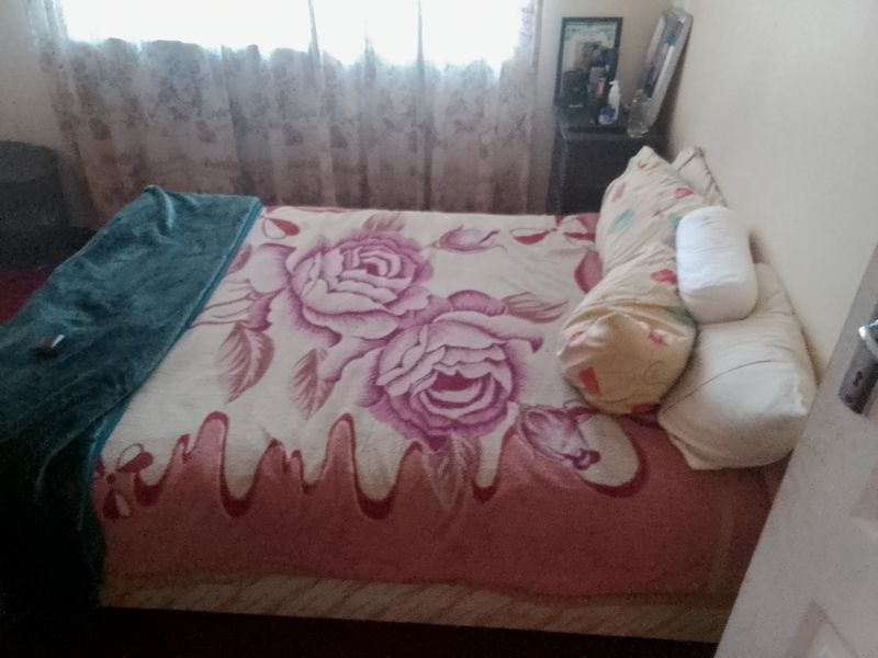A standard bedroom featuring a window with curtains.