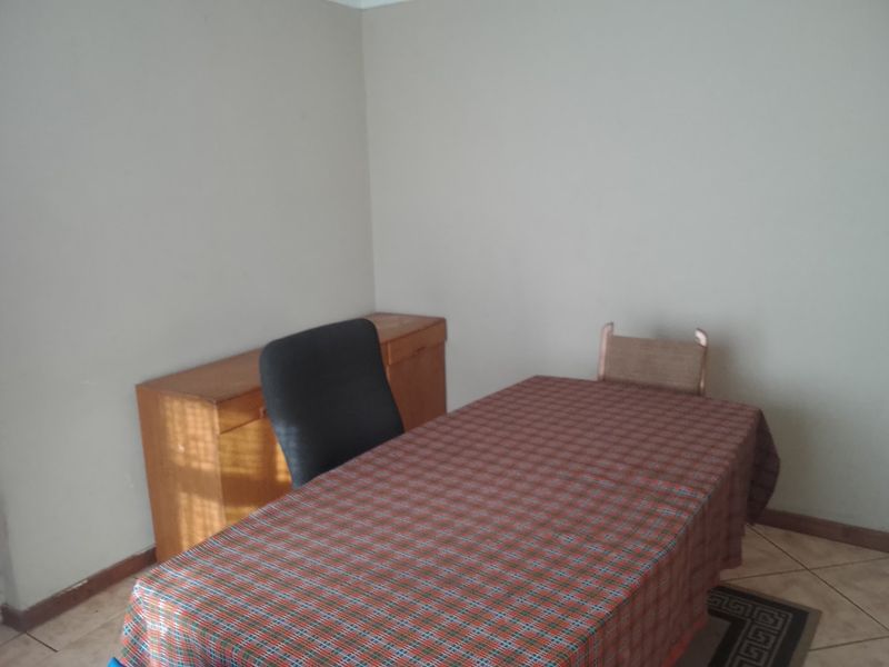A simple room featuring tiled flooring, suitable for use as a home office or study area.
