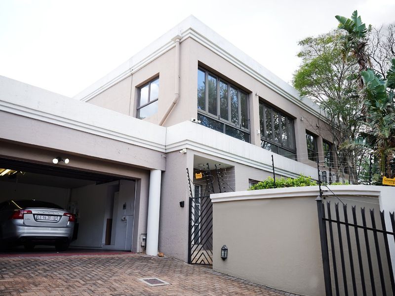 Modern double-storey residence featuring a paved driveway, integrated double garage, and secure boundary wall with electric fencing.
