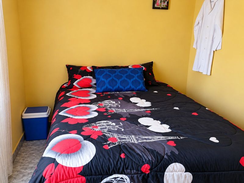 A bedroom featuring yellow walls and tiled flooring, providing a functional space for rest.