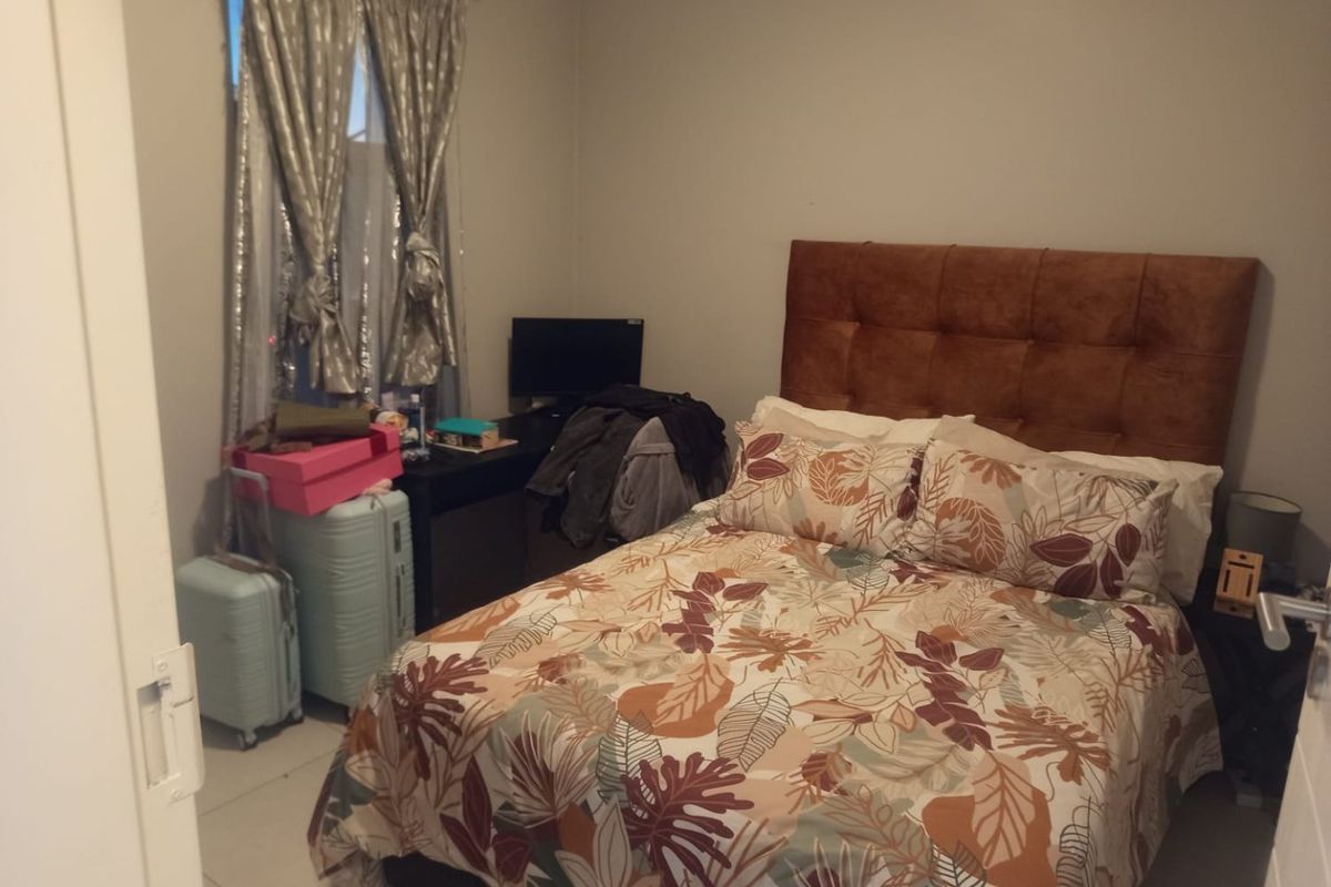 A functional bedroom featuring tiled flooring and a window, providing a comfortable space for rest.