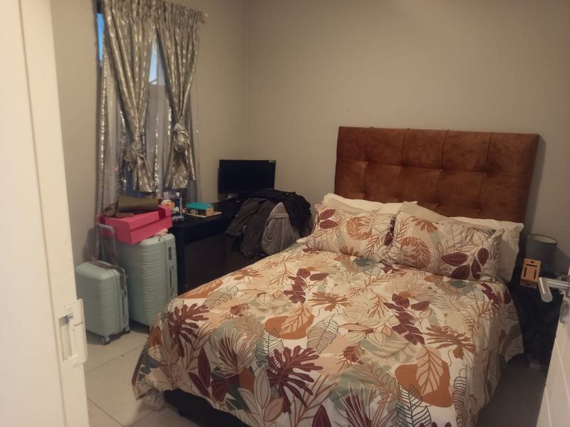 A functional bedroom featuring tiled flooring and a window, providing a comfortable space for rest.