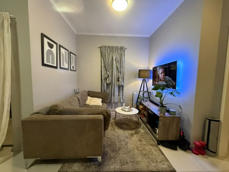 A cozy living room featuring tiled flooring and neutral wall tones, providing a functional and comfortable space for relaxation.