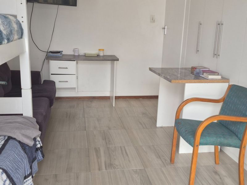 A functional bedroom featuring built-in cupboards and tiled flooring, providing practical storage and living space.