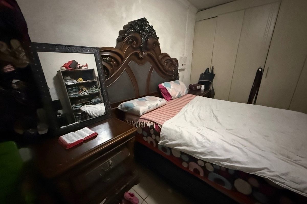 A bedroom featuring built-in cupboards and a dated interior finish, offering potential for modernization and cosmetic updates.