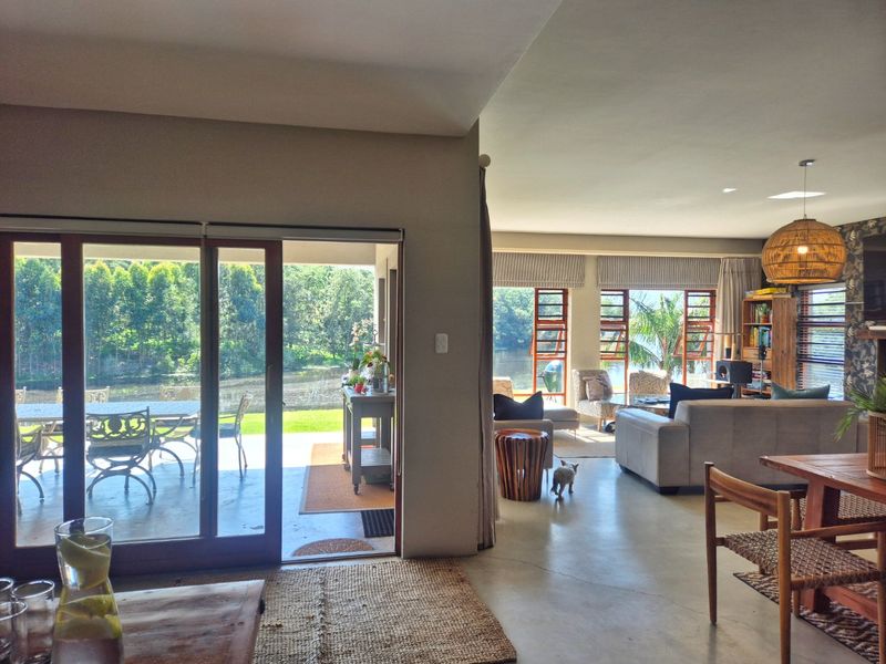 Spacious open-plan living area featuring polished concrete floors and large sliding doors that provide seamless access to the outdoor patio and scenic views.