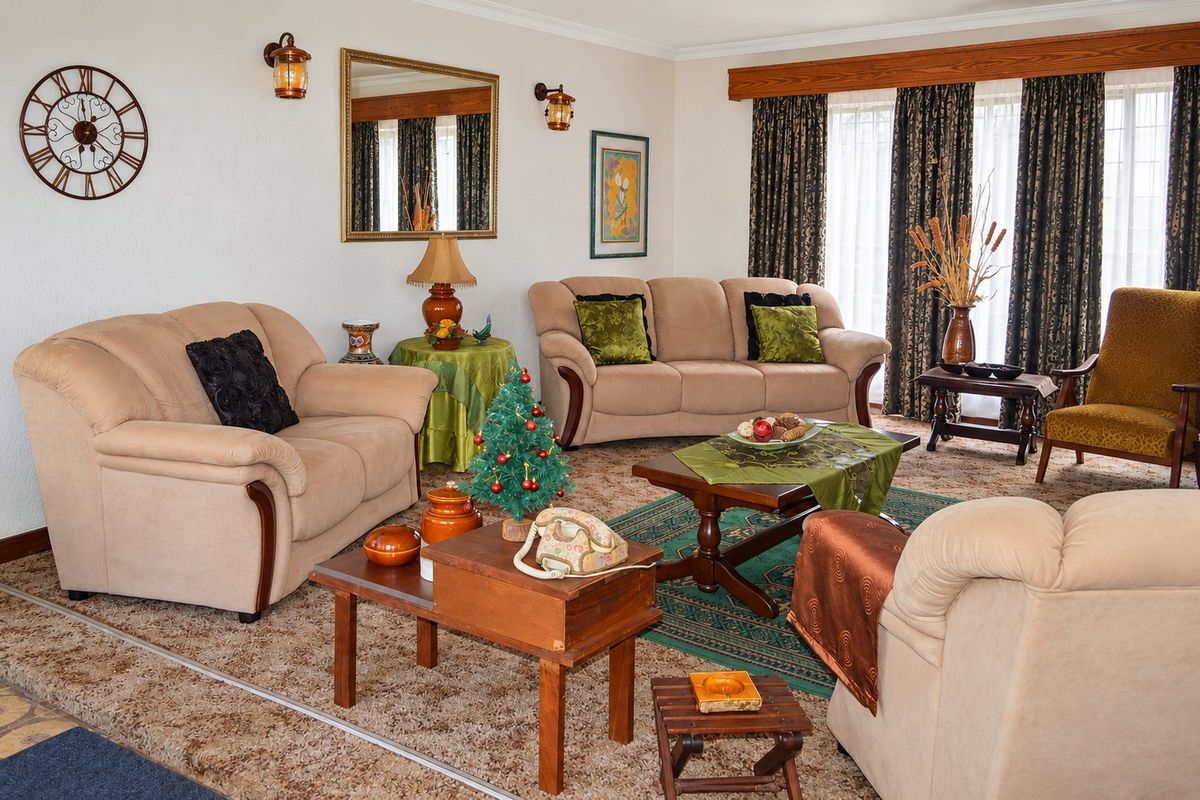 A traditional living room featuring wall-mounted lighting, a timber window pelmet, and access to the outdoors via sliding glass doors.