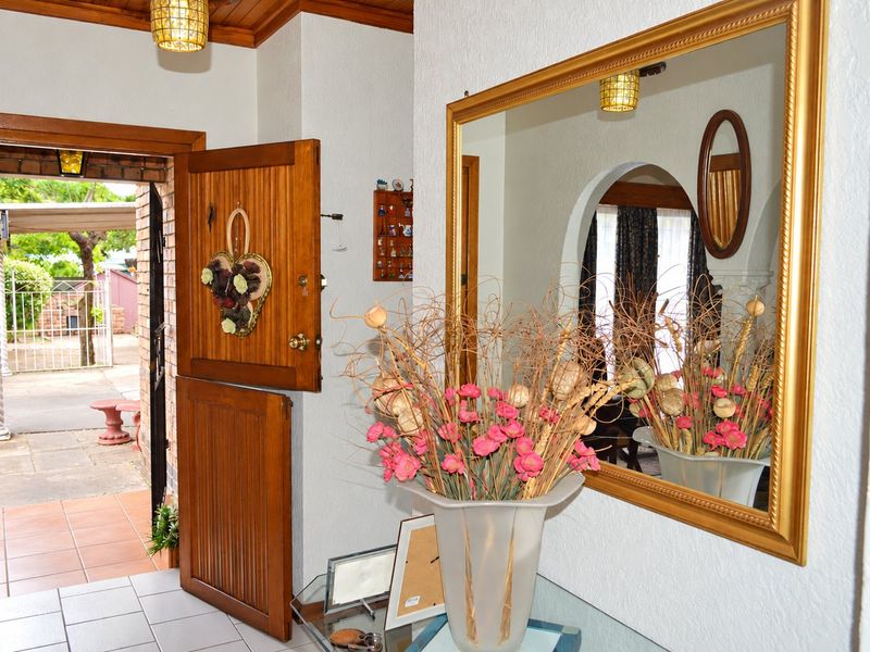 Welcoming entrance hall featuring a classic timber stable door, tiled flooring, and a warm timber ceiling with an arched transition to the living area.