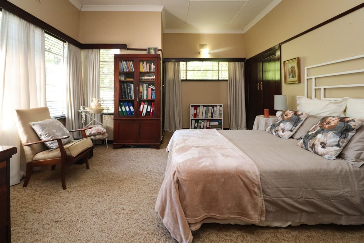 Spacious bedroom featuring classic picture rails, built-in cupboards, and large windows that provide ample natural light.