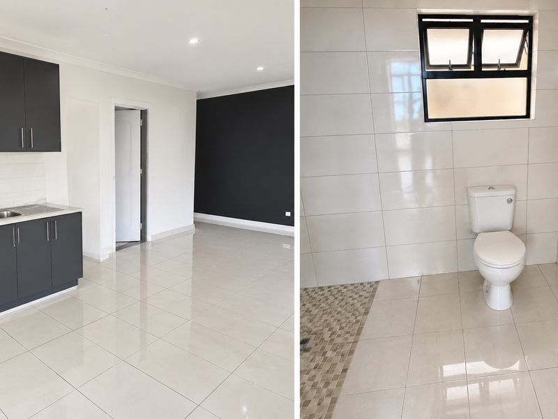 A bright open-plan apartment featuring a modern kitchen with dark cabinetry and a clean, tiled bathroom with contemporary fixtures.