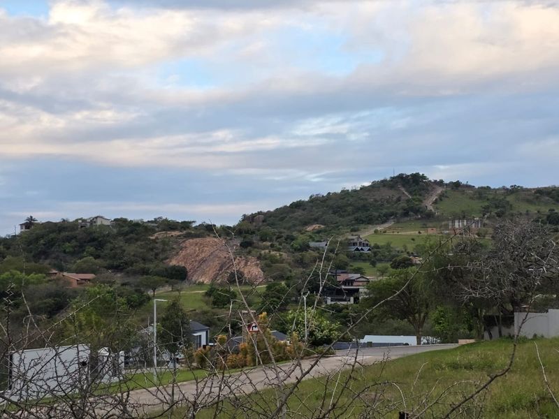 A scenic view of the surrounding hilly landscape and residential neighborhood, showcasing the natural topography and local environment.