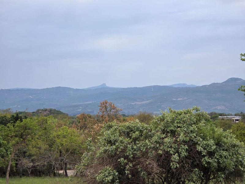 A scenic view of the surrounding mountain landscape and natural vegetation, showcasing the natural beauty of the property's location.