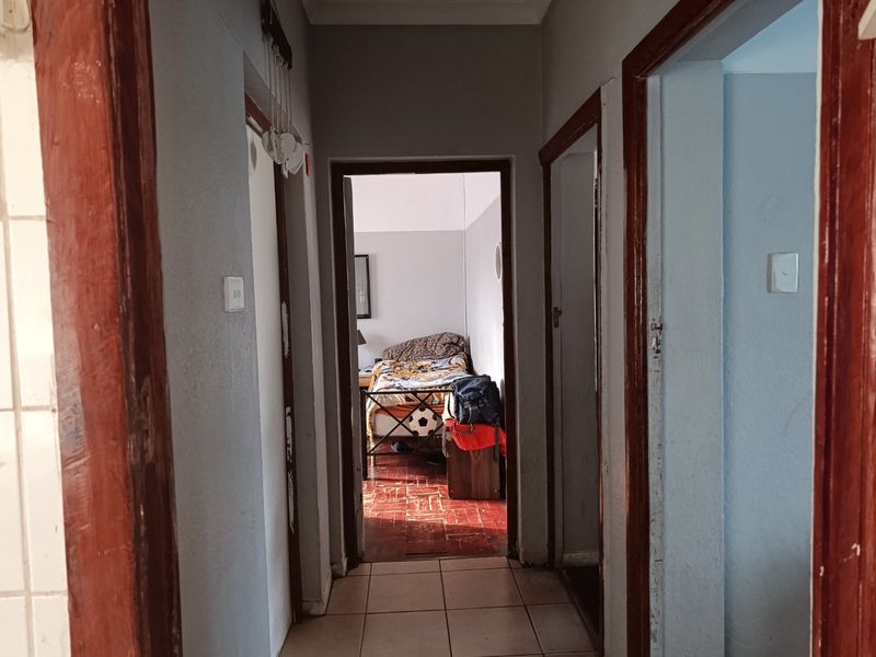 A functional hallway featuring tiled flooring and wooden door frames, providing access to adjacent rooms within the apartment.