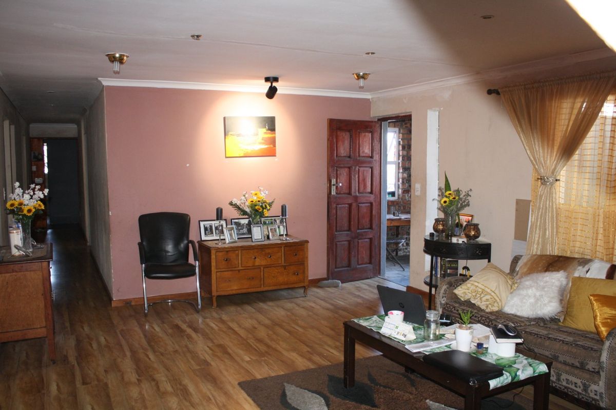 A living room featuring laminate flooring and recessed lighting, with potential for cosmetic updates to the wall finishes to enhance the space.