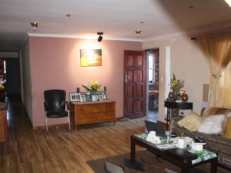 A living room featuring laminate flooring and recessed lighting, with potential for cosmetic updates to the wall finishes to enhance the space.