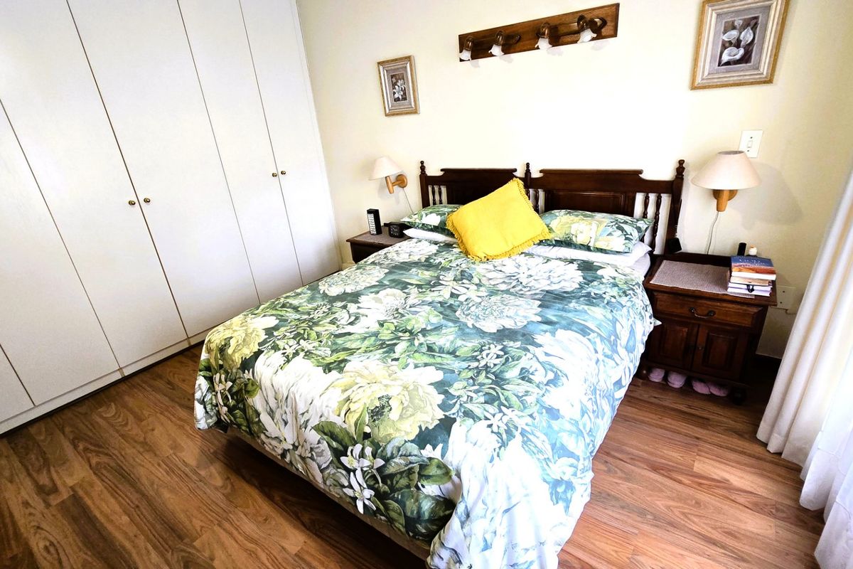 A functional bedroom featuring laminate flooring and ample built-in cupboard storage space.