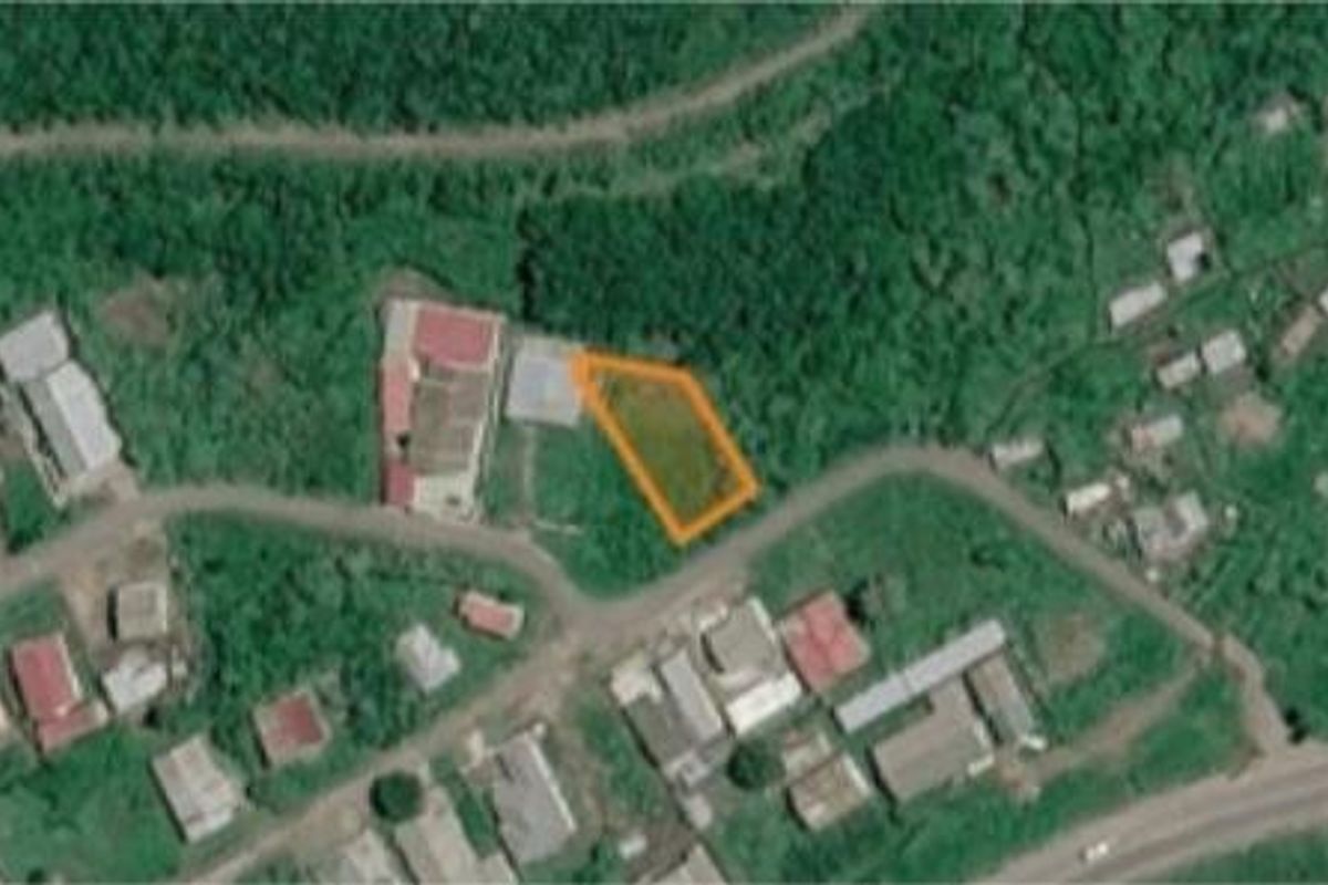 An aerial view showing the vacant residential land plot highlighted in orange, situated within a developed neighborhood.