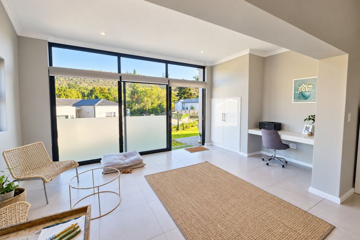 Bright living area featuring large sliding glass doors, tiled flooring, recessed lighting, and a convenient built-in desk and storage unit.