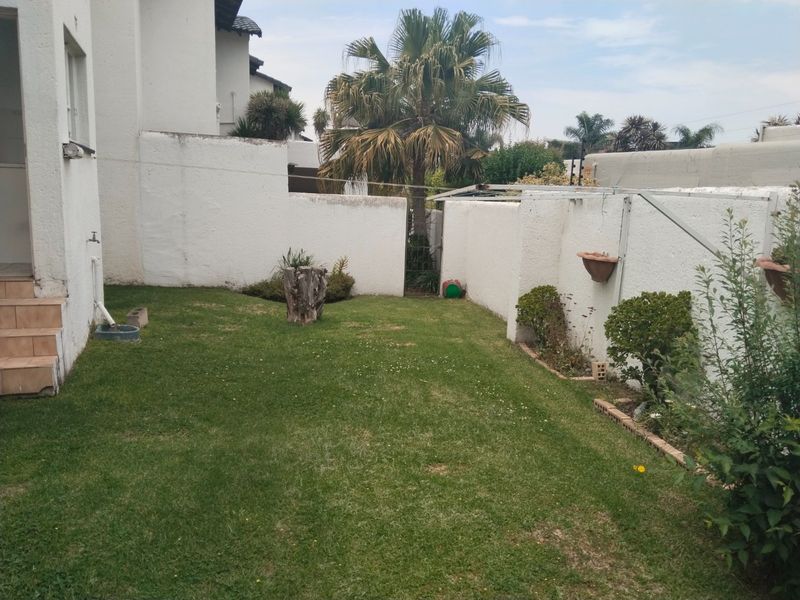 A private rear garden area featuring a lawn, boundary walls, and an outdoor utility tap, offering potential for landscaping improvements.