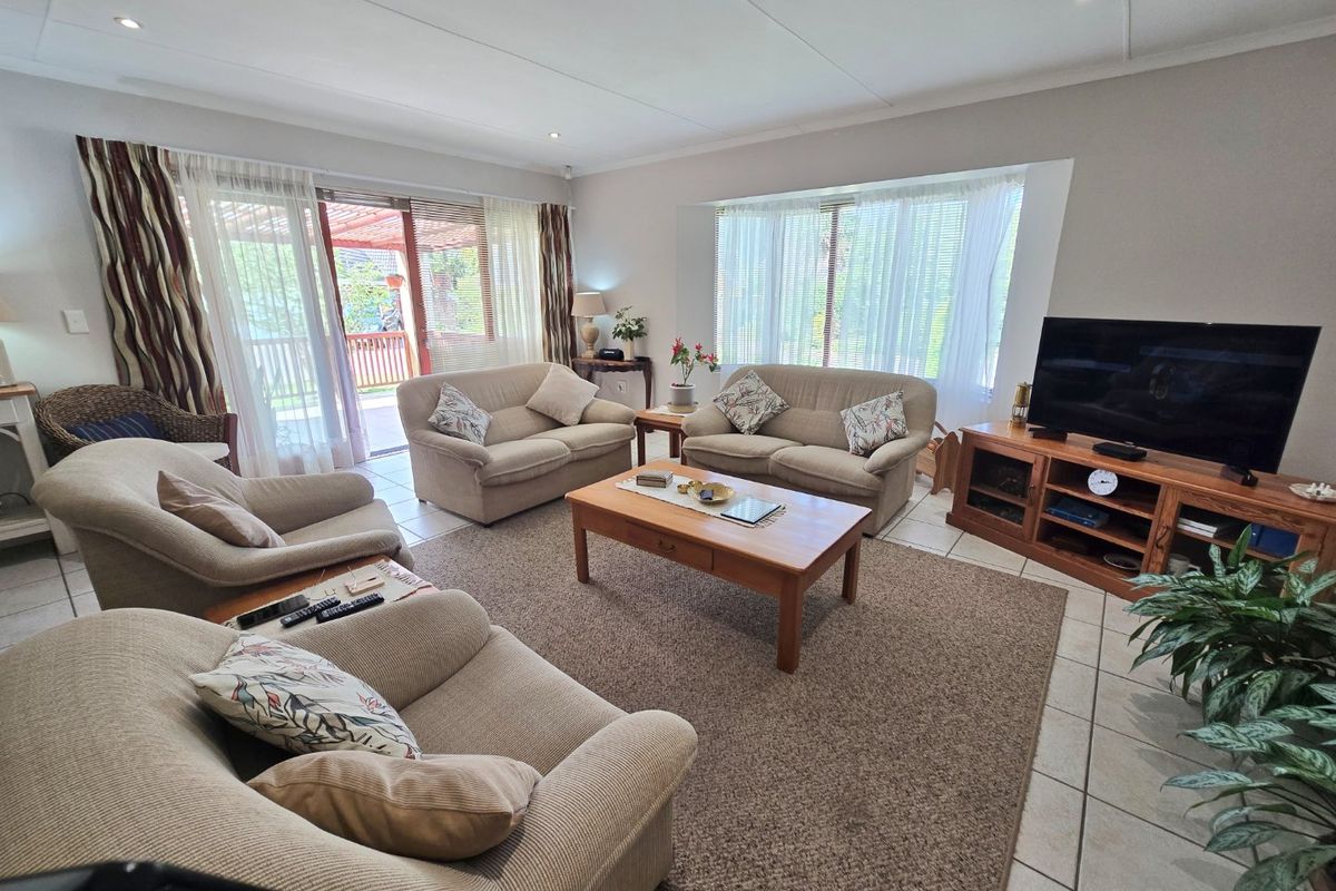 Spacious living room featuring tiled flooring, recessed lighting, and large windows with direct access to an outdoor patio area.